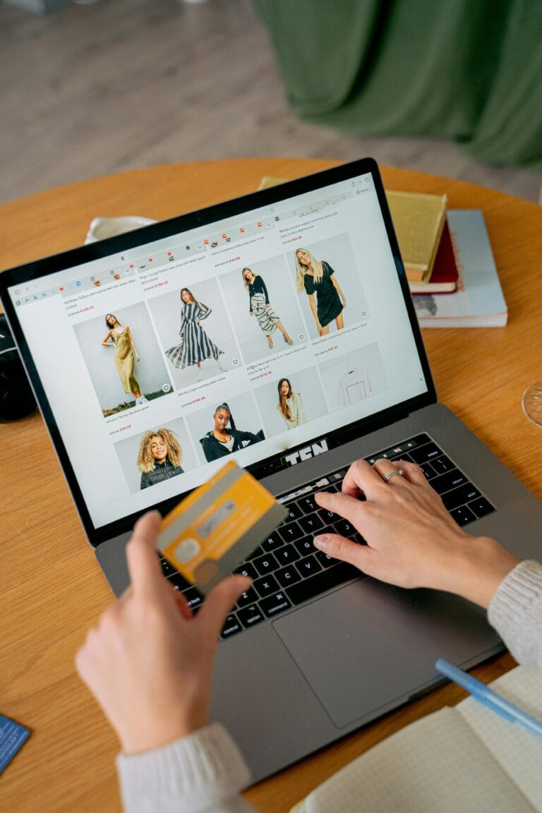 Ecommerce SEO Service In Delhi India A woman makes an online purchase using a credit card on her laptop, browsing an online fashion store.